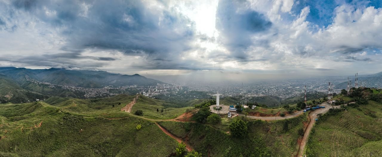 Aerial panorama of the Cristo Rey statue on a green hilltop above Cali, Colombia