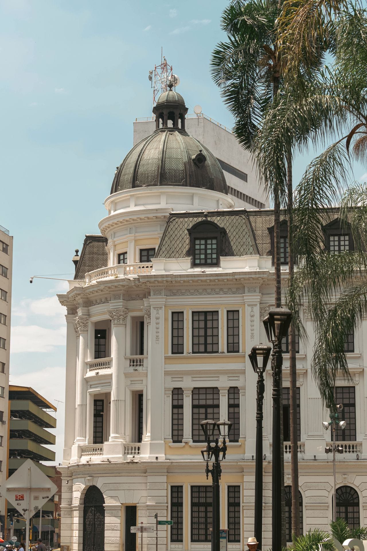 White domed historic building with palm trees in downtown Cali, Colombia