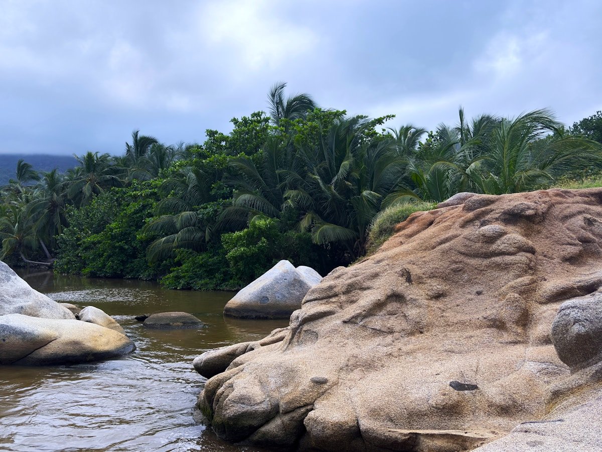 Tropical river with large rocks and palm trees on Colombia's Caribbean coast