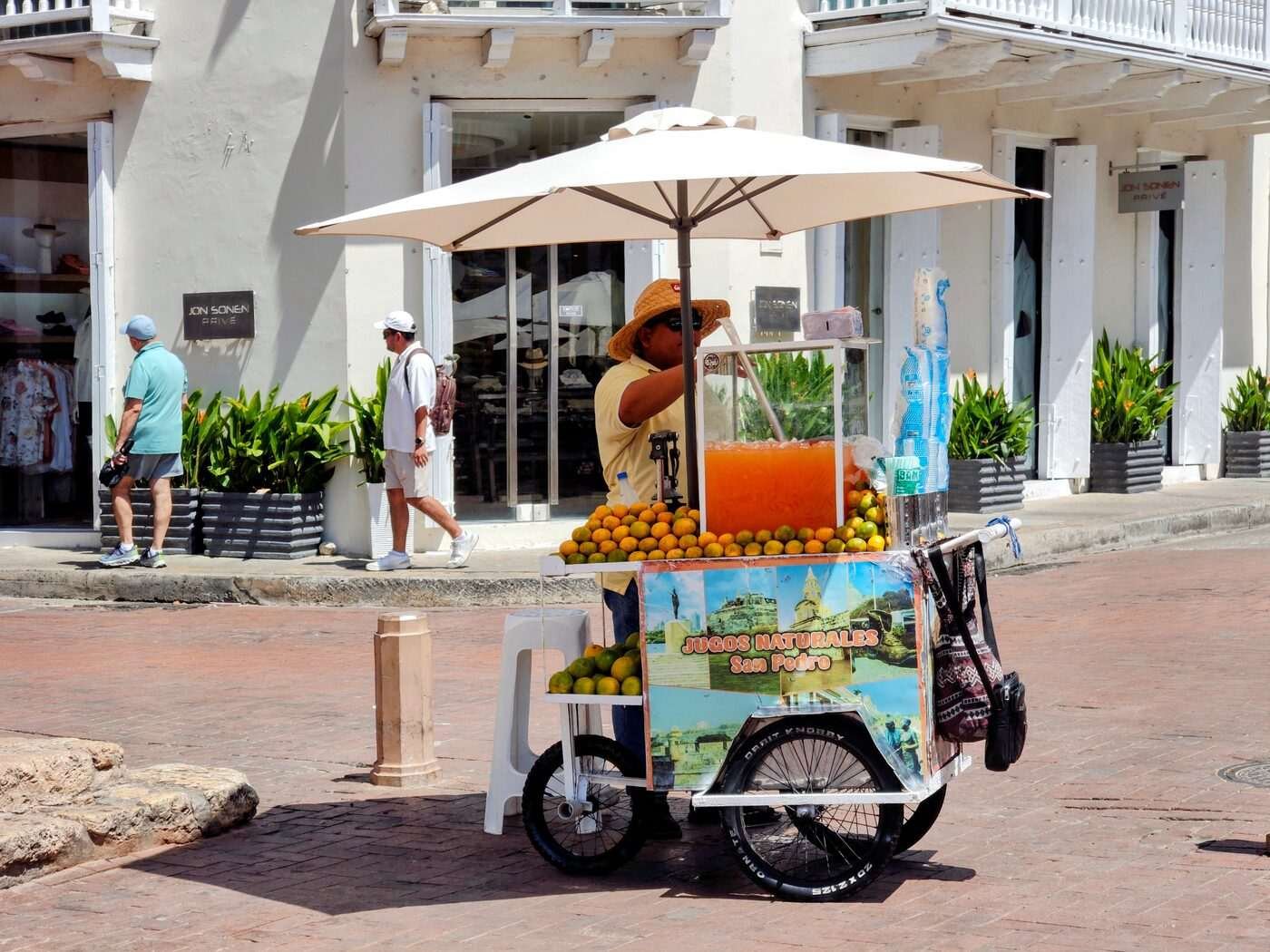 Street vendor pressing fresh orange juice on a sunny day, Caribbean coast, Colombia