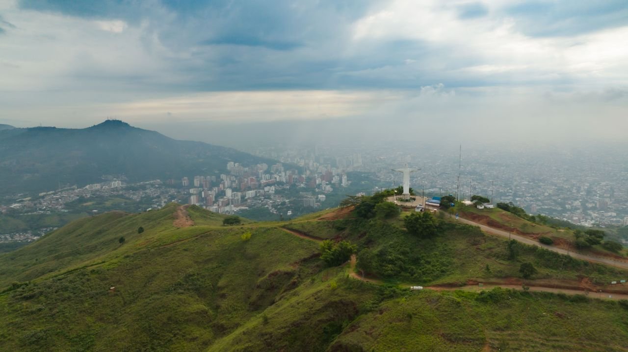Cristo Rey statue on a green ridge above Cali, Colombia, with the city spread out below