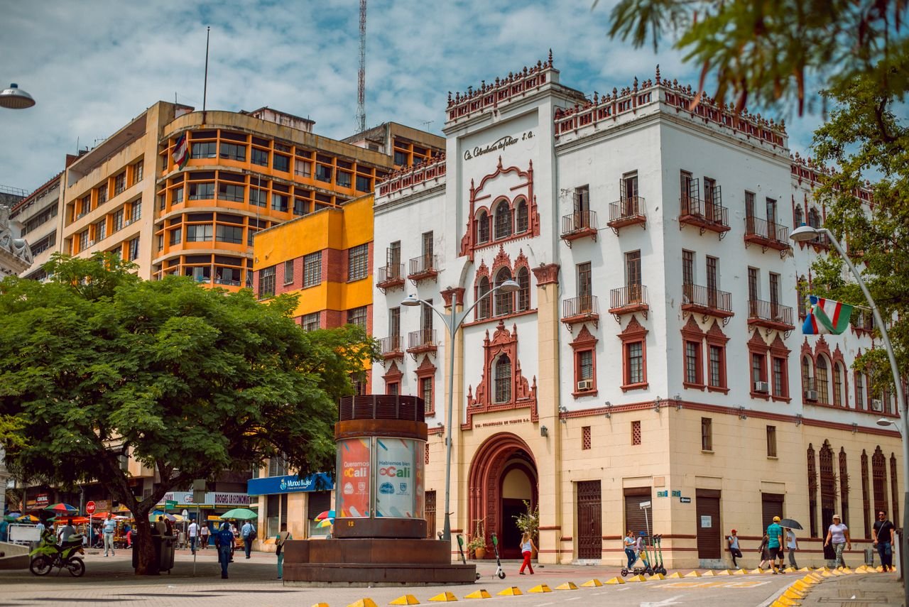 Historic Coltabaco building and busy plaza in central Cali, Colombia on a sunny day
