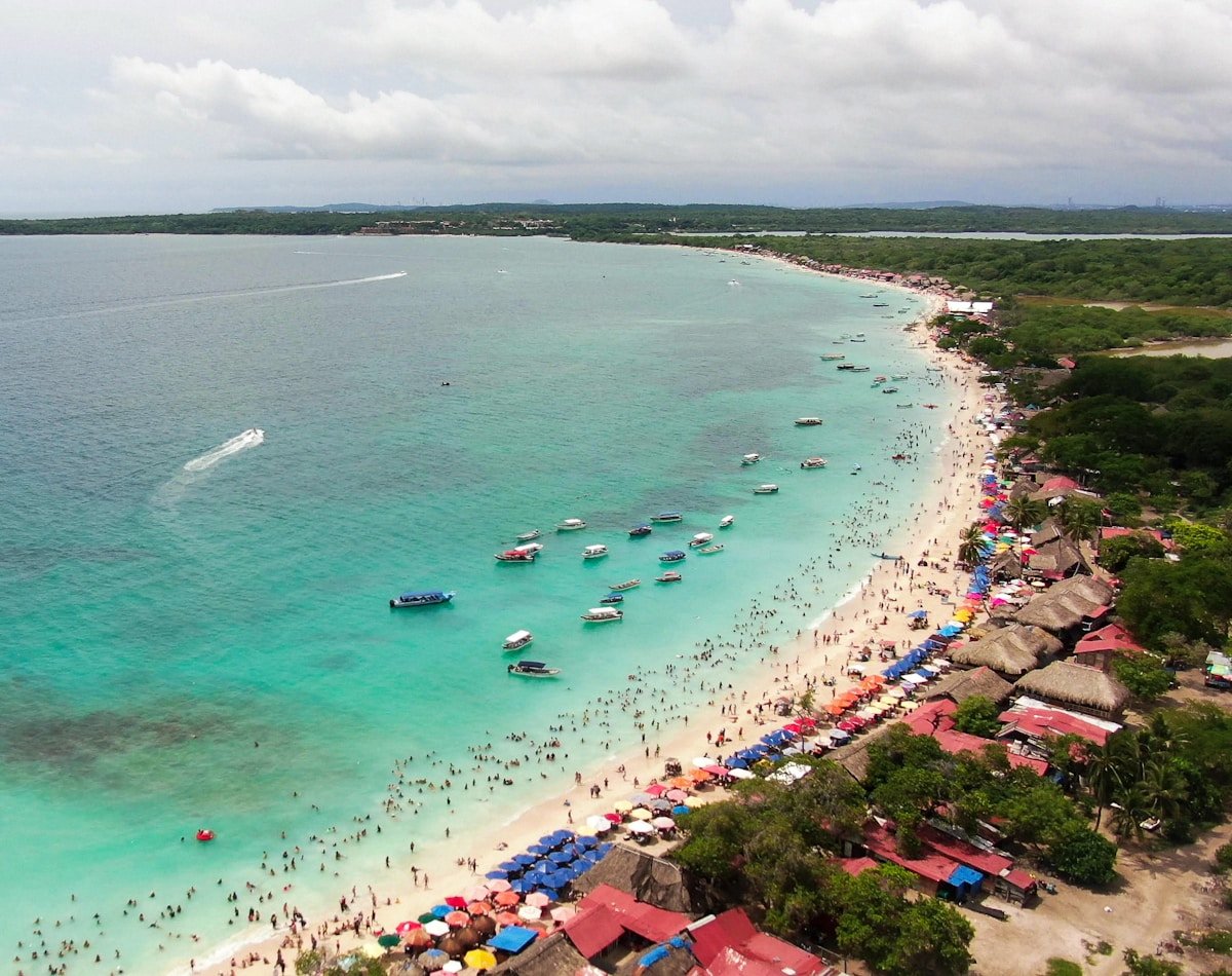Aerial view of Playa Blanca on Isla Barú near Cartagena with turquoise Caribbean water and brightly coloured beach umbrellas