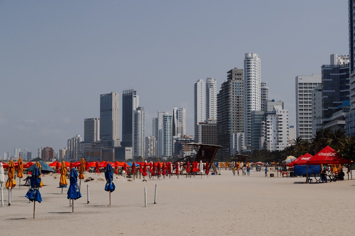 Cartagena's Bocagrande beach with colourful umbrellas in the foreground and the city's high-rise skyline behind