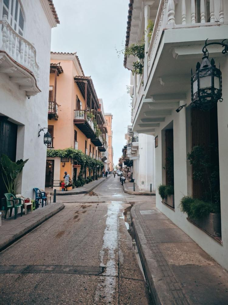 Pastel colonial street with wooden balconies and iron lanterns in Cartagena's Walled City