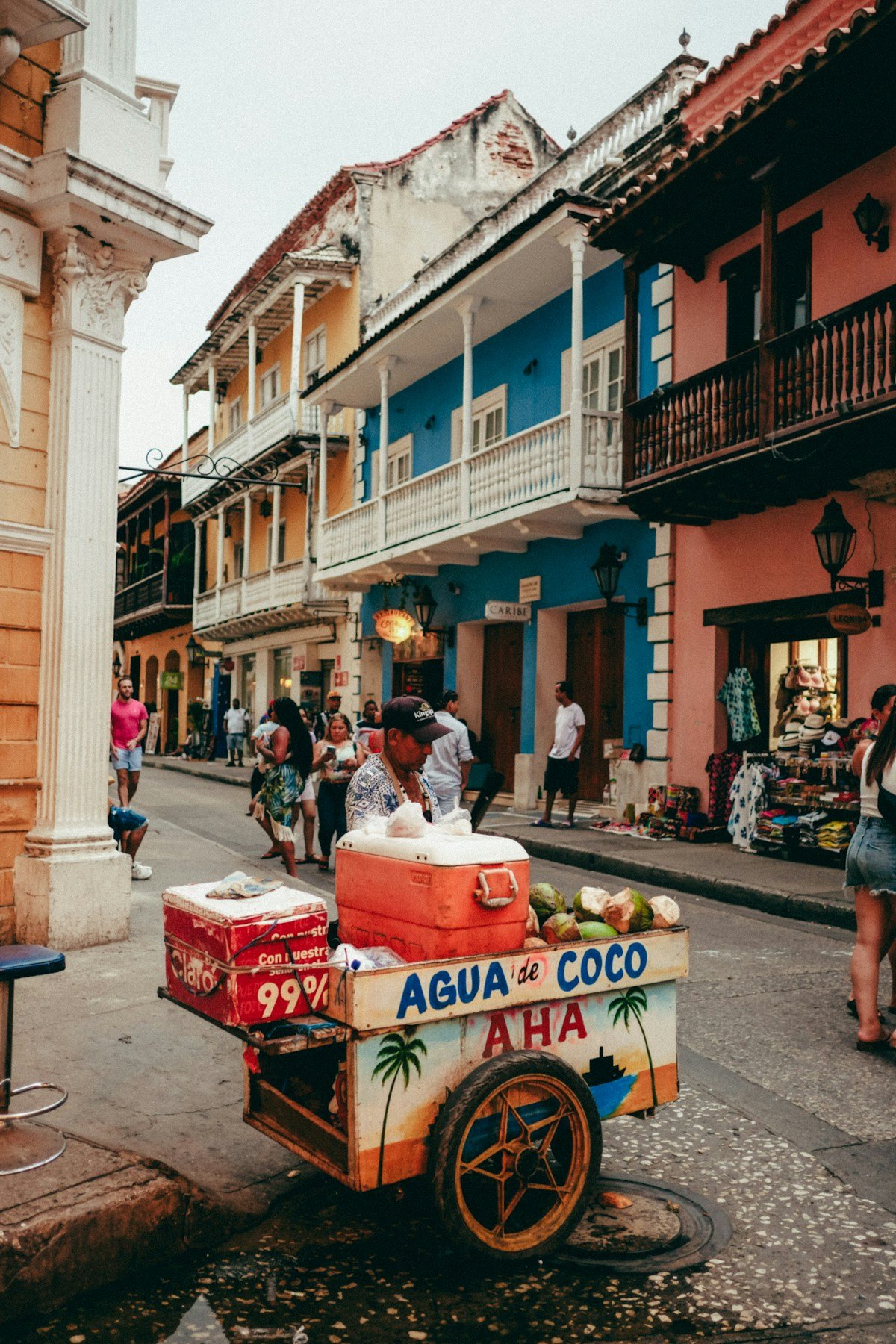 Street vendor pushing an Agua de Coco cart through colonial streets of Cartagena, Colombia