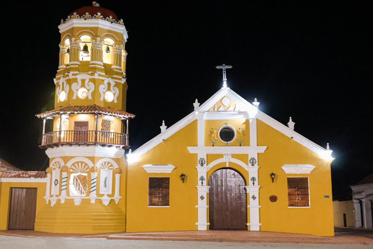 Calle colonial de Mompox con la iglesia de Santa Barbara al fondo y palmeras a la orilla del rio Magdalena
