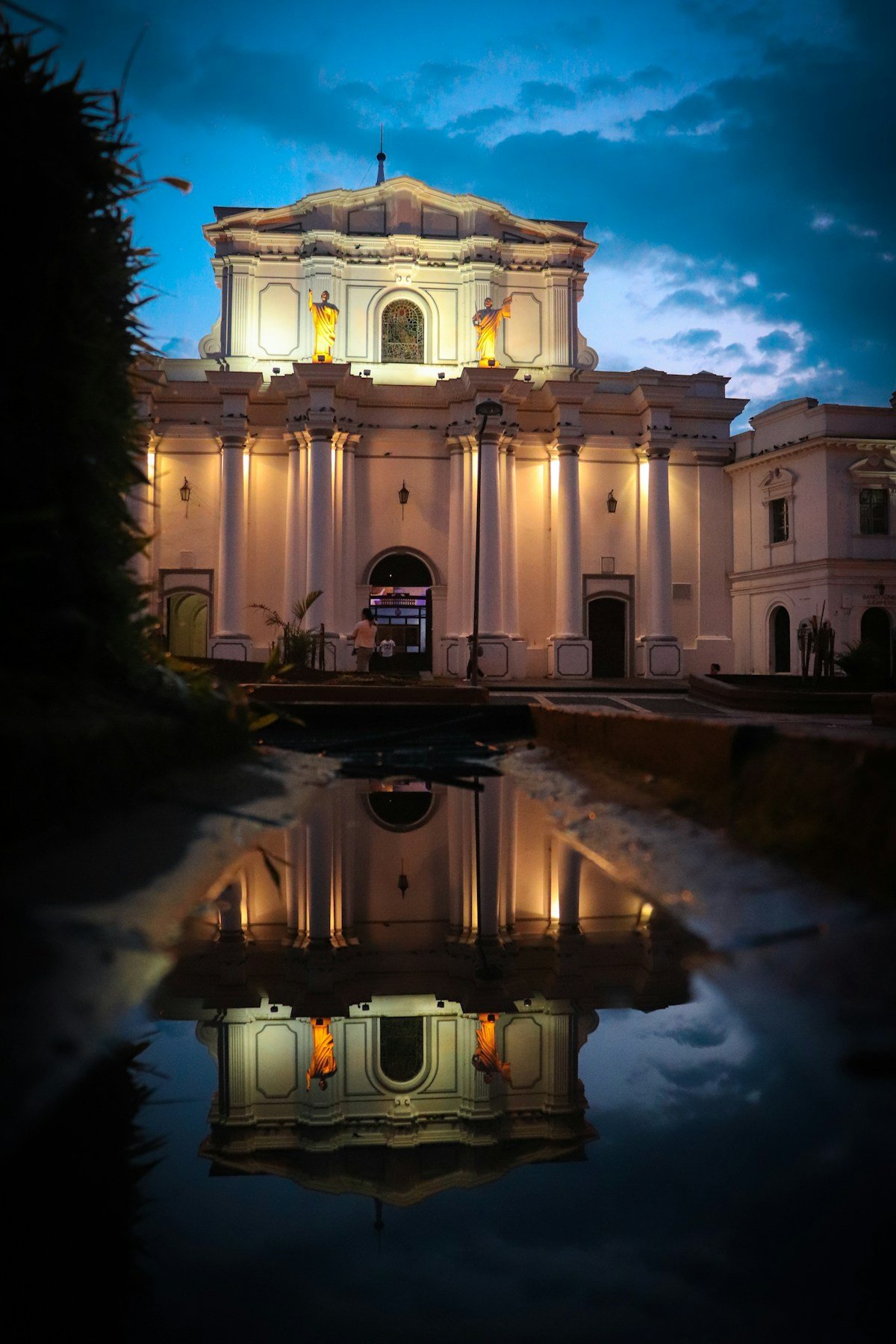 Illuminated white colonial church reflected in water, Popayan, Colombia