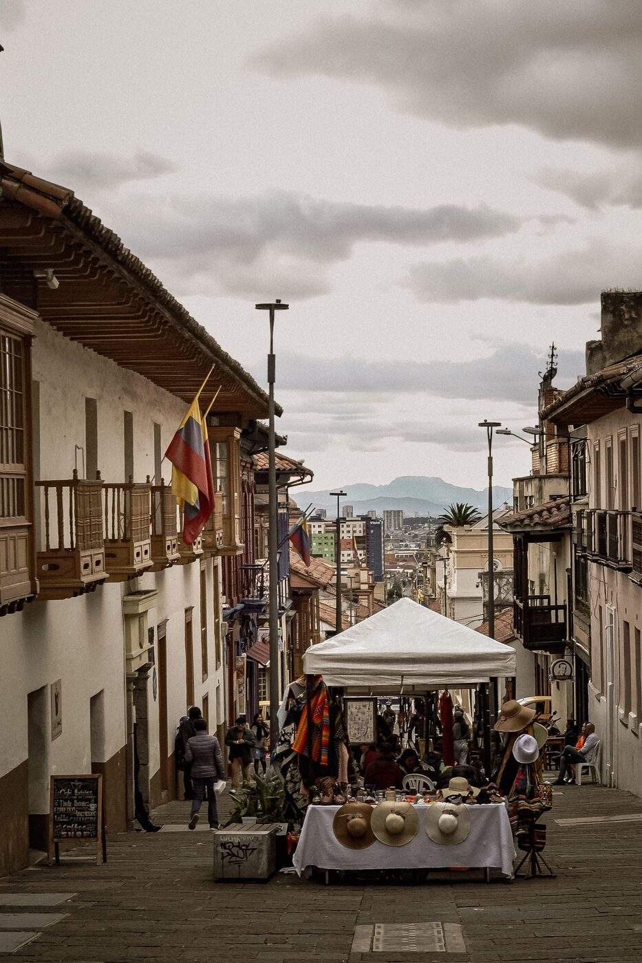 Street market stall with Colombian flag and artisan goods on a colonial street in Bogota