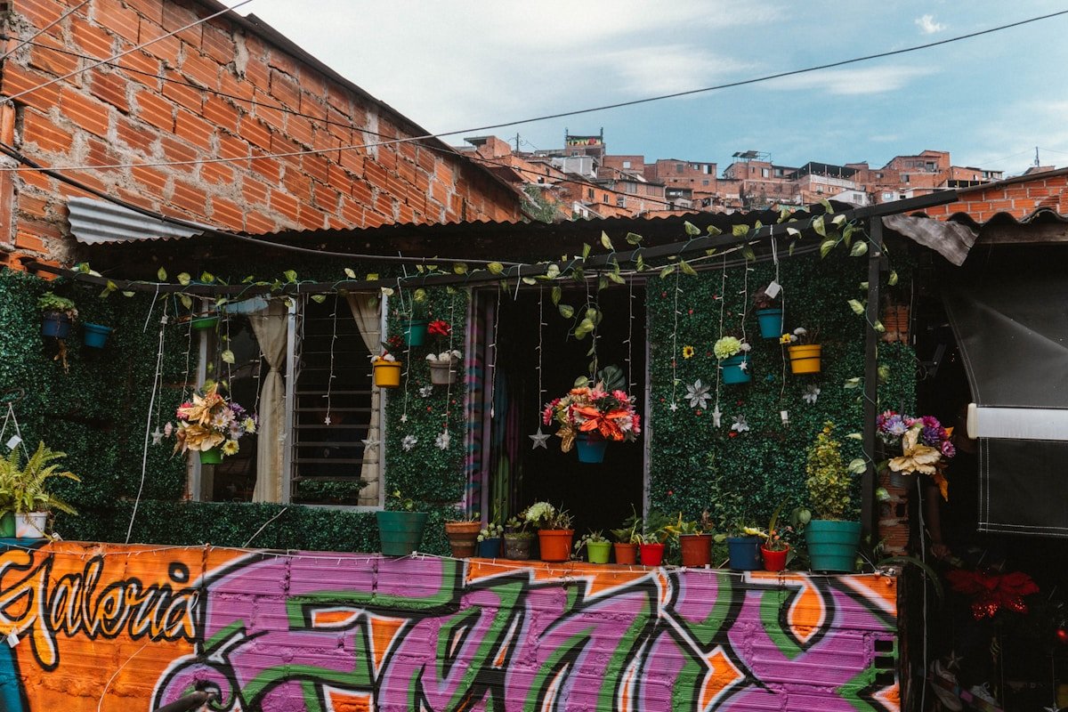 Colourful murals and hanging plants on a building in Medellin's Commune 13, Colombia