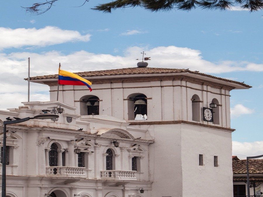 Whitewashed colonial bell tower with Colombian flag flying above Popayán historic centre, Cauca, Colombia