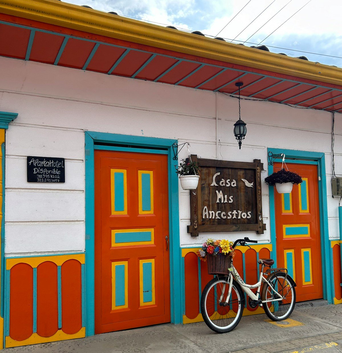 A colourfully painted bicycle leaning against a brightly decorated building facade in Salento, Colombia