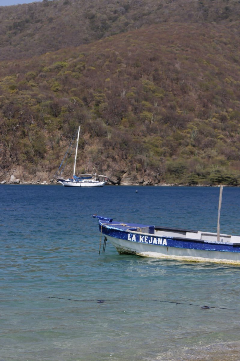 Fishing boats anchored in a calm bay below dry hills near Santa Marta