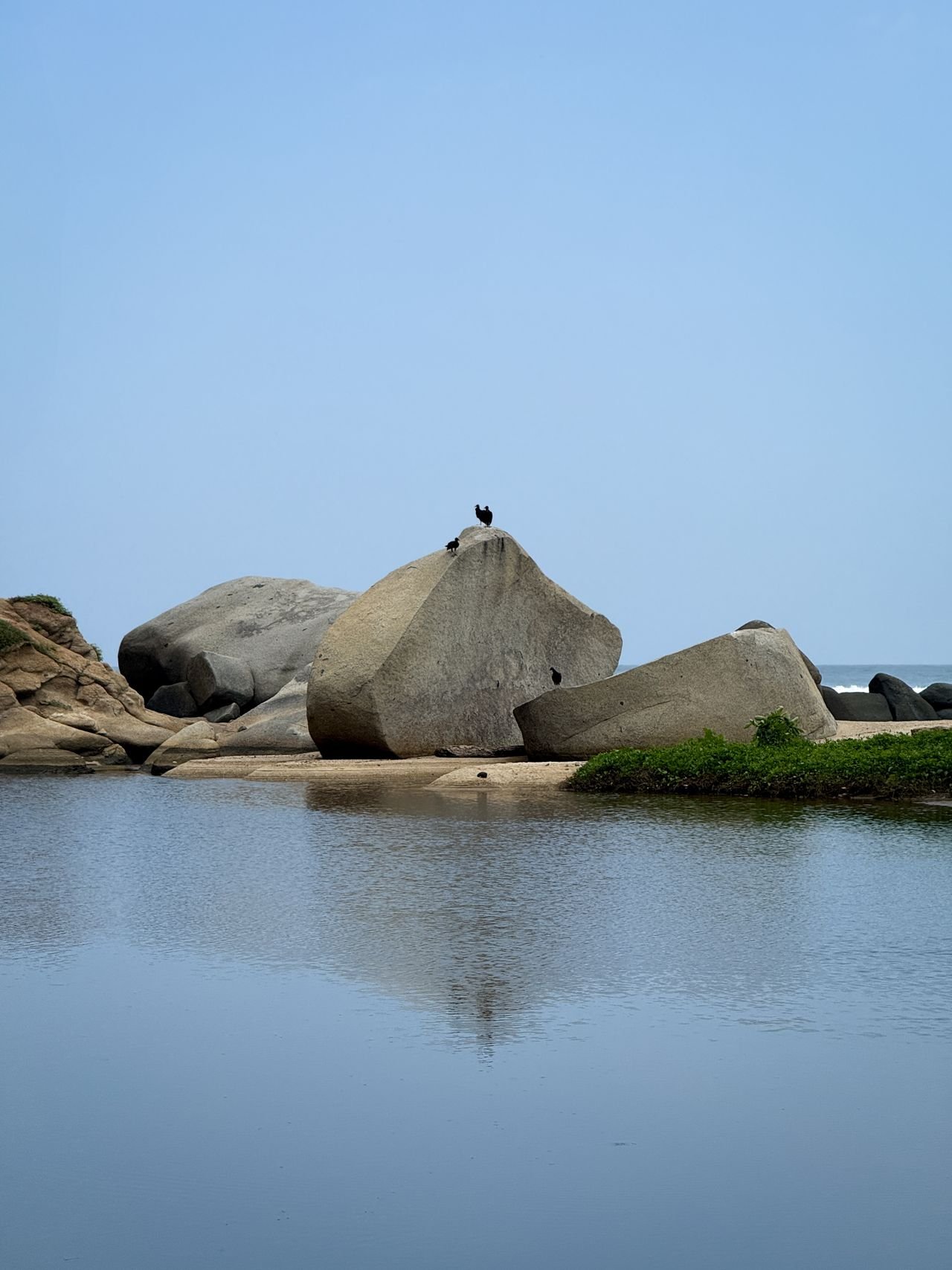 Granite boulders and still water at a Tayrona shoreline