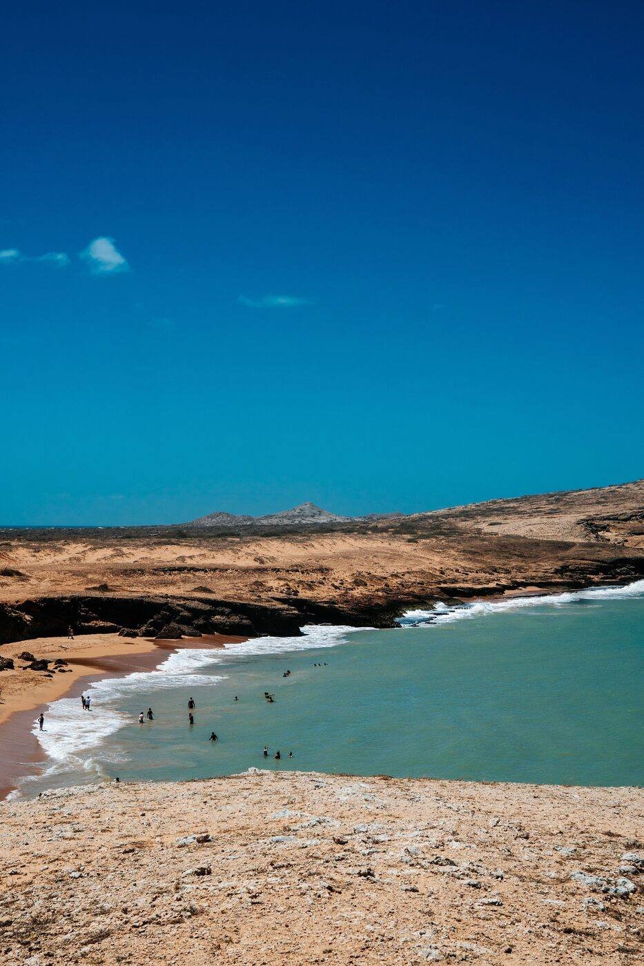 Arid desert landscape meeting turquoise Caribbean water at a beach in La Guajira, Colombia