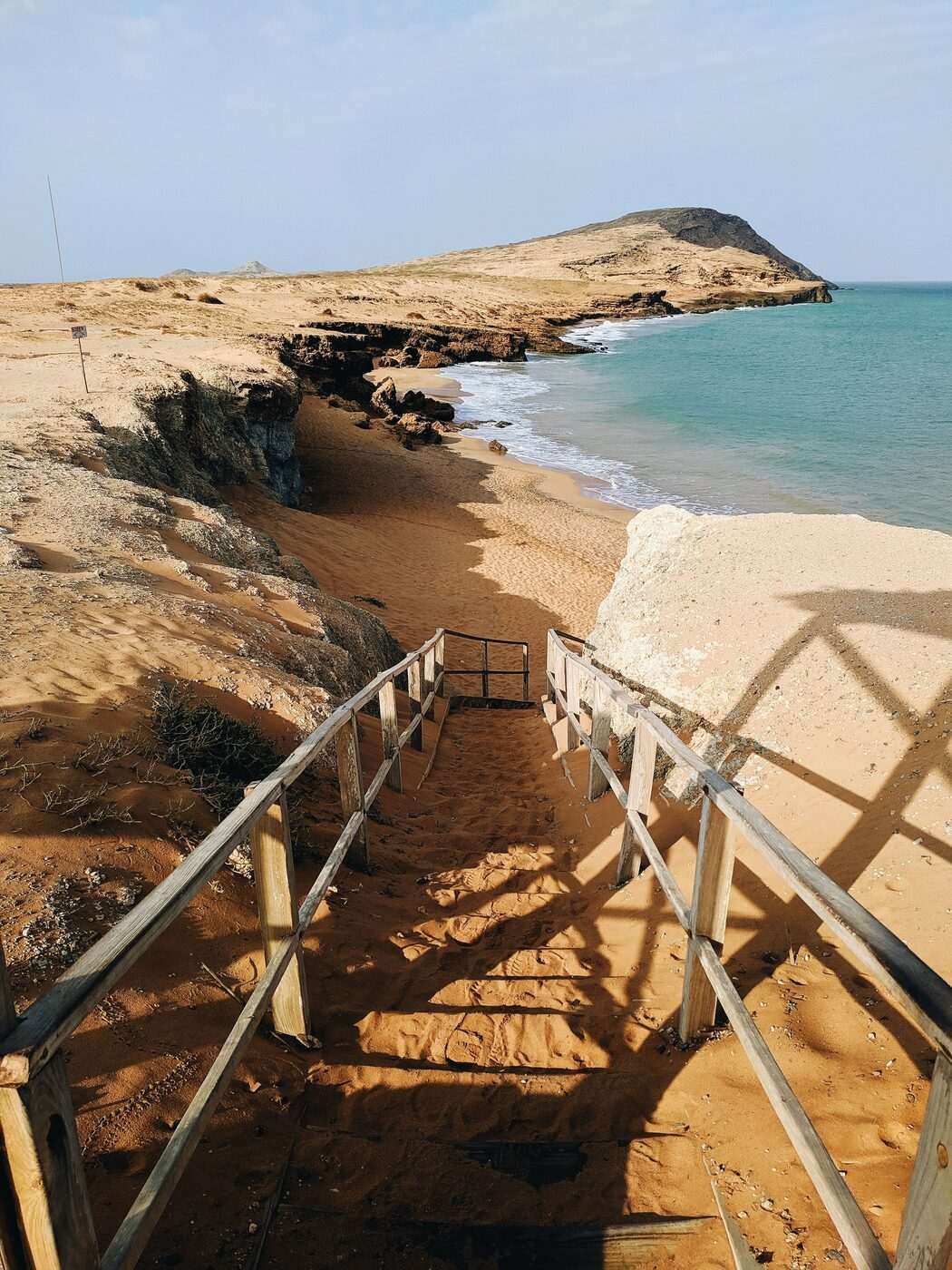 Metal staircase descending to a deserted desert beach at Cabo de la Vela, La Guajira, Colombia