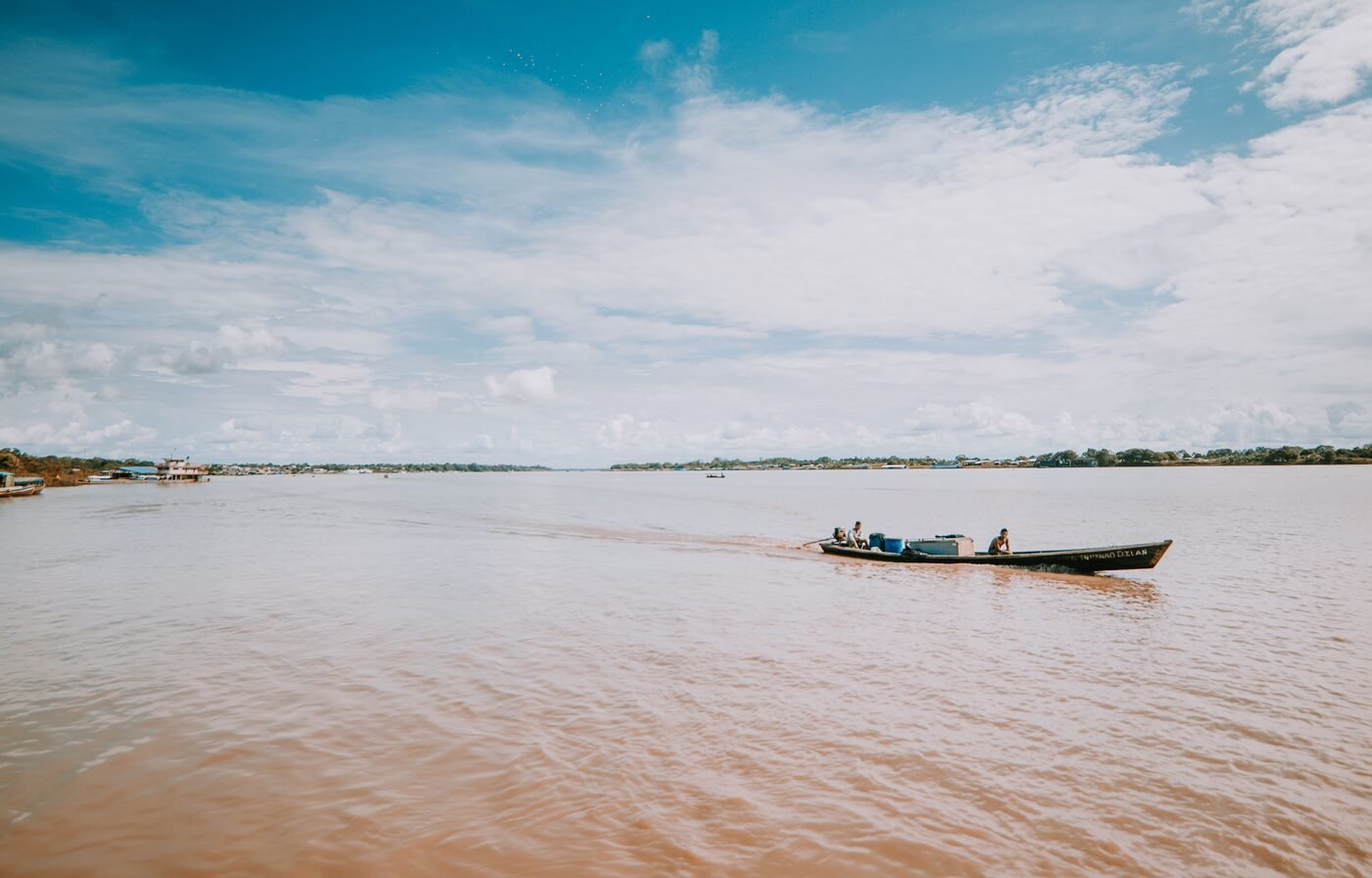 Wooden motorboat travelling on the wide brown Amazon River in Leticia, Colombia