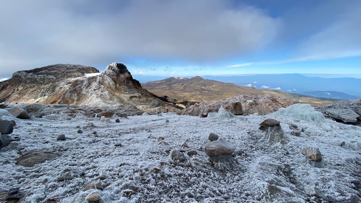 Frost-covered volcanic rocks at the summit zone of Los Nevados National Park, Colombia, with blue sky
