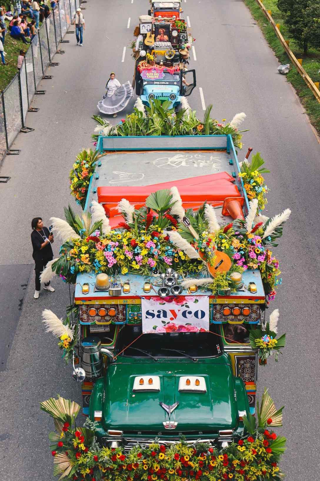 Flower-adorned chiva buses parading at Medellín's Feria de las Flores, Colombia