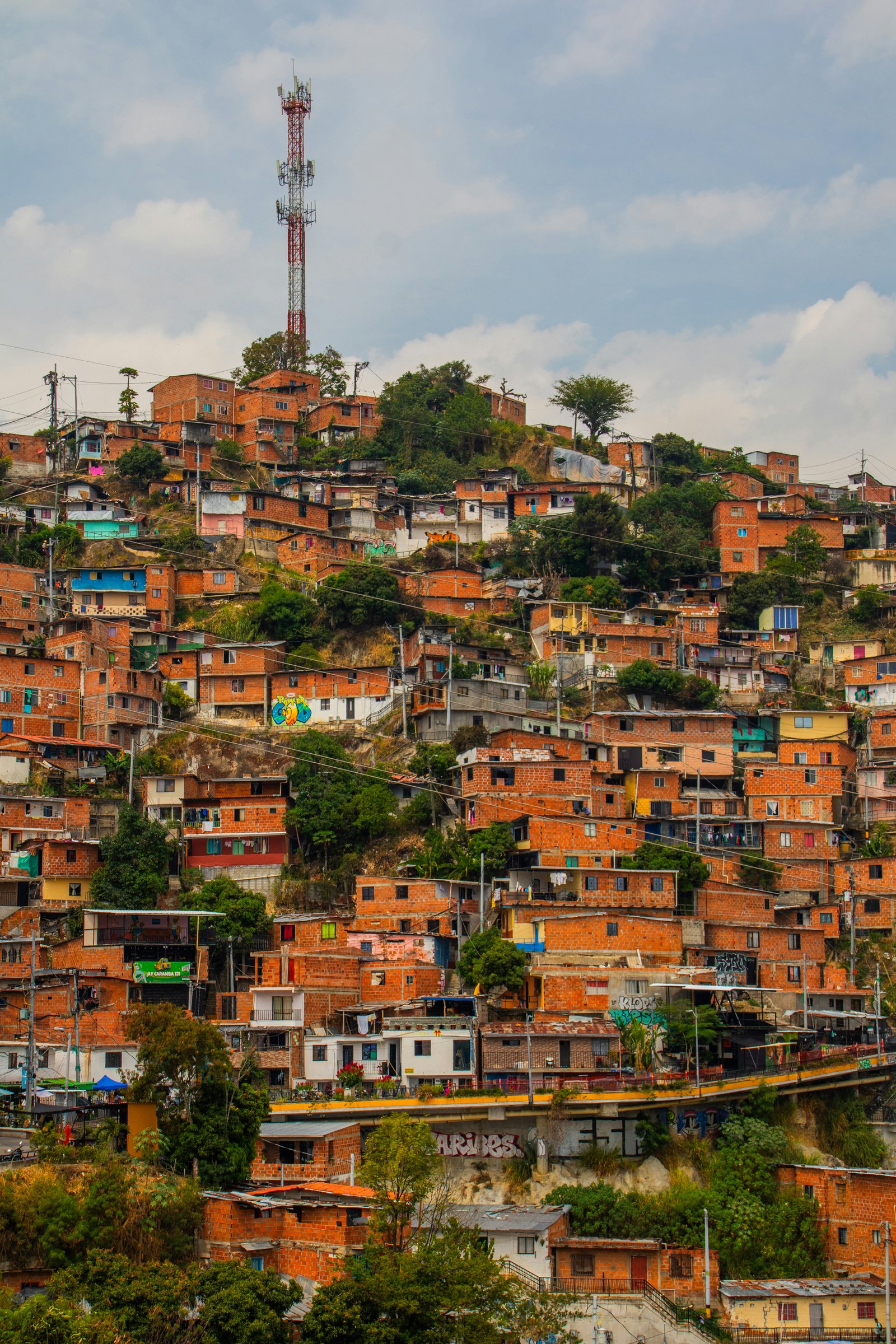Dense hillside neighbourhood with brick houses and colourful street art in Medellin, Colombia