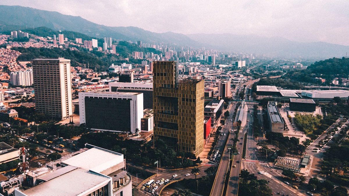 Aerial view of Medellin city skyline with tall buildings and the Andes mountains in the background