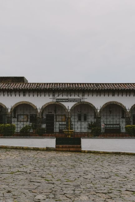 Hotel courtyard in Popayán with whitewashed colonial walls, arched corridors, and potted plants