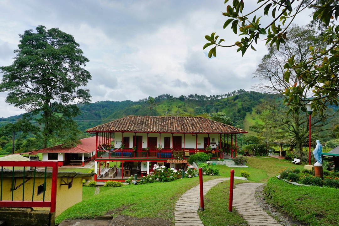 A traditional colonial guesthouse in Salento, Colombia, with a colourful painted facade and flower-filled balcony