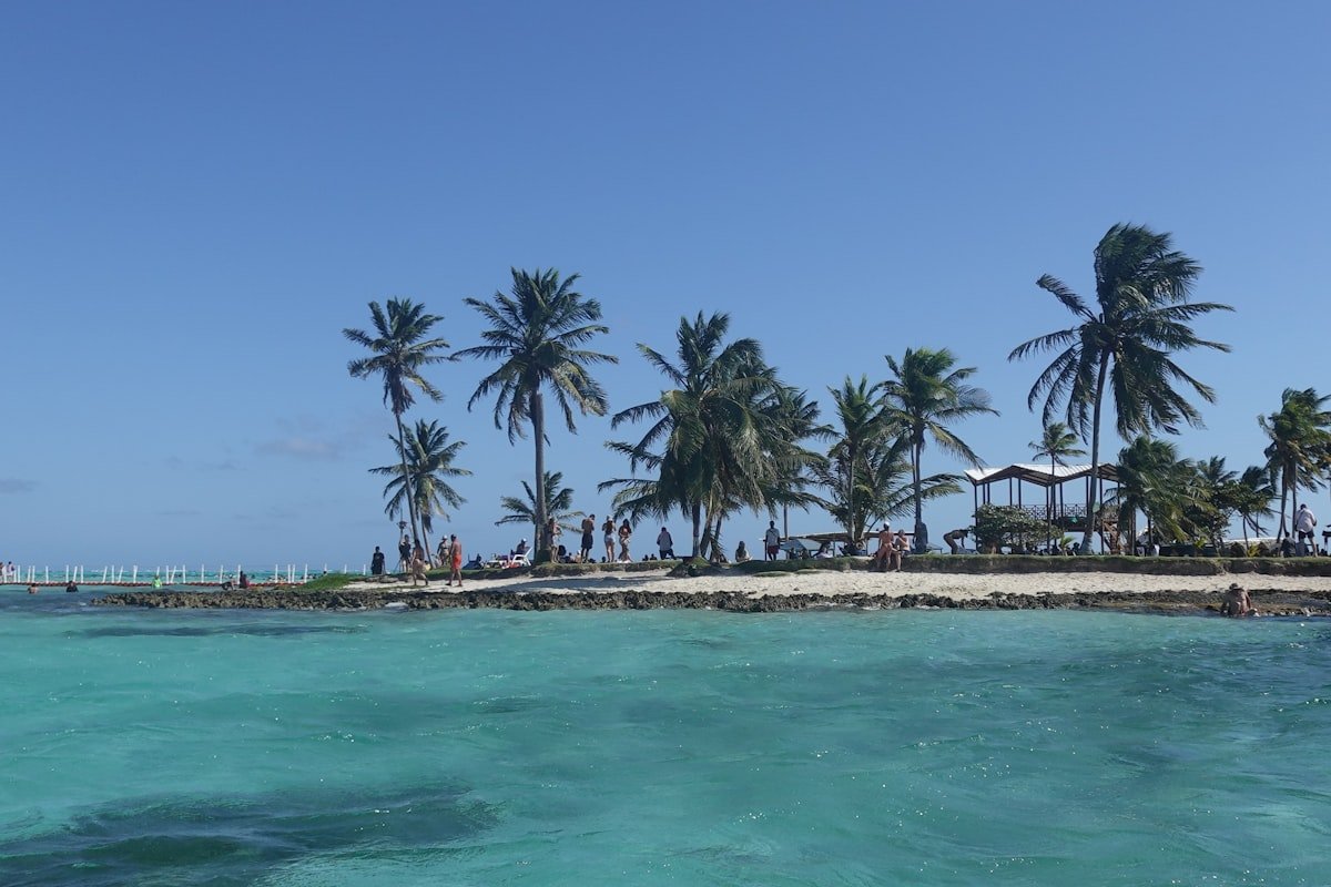 Turquoise Caribbean water lapping a palm-fringed sandy islet at San Andrés, Colombia