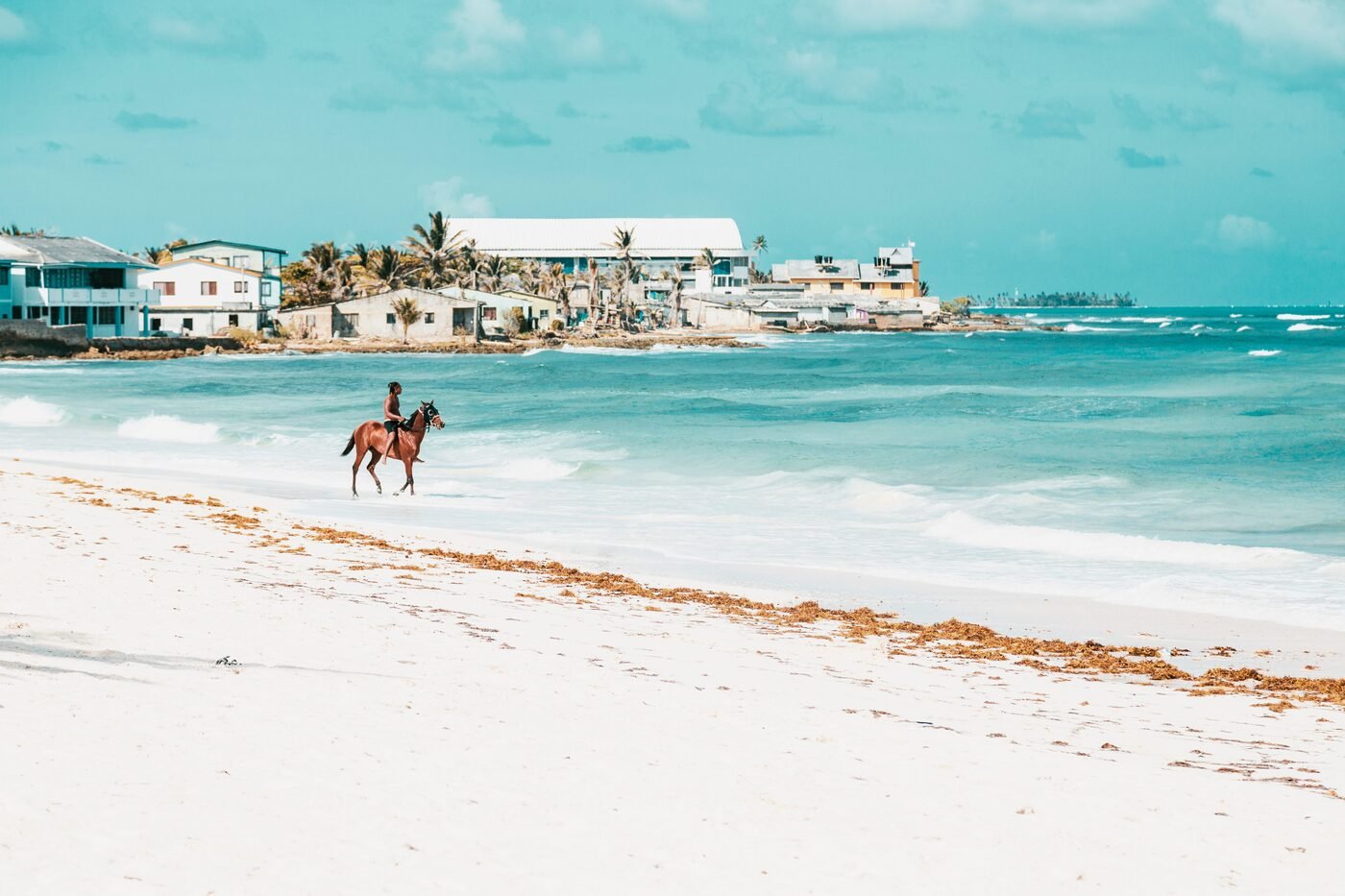 Horseback riding along the white sand beach of San Andres Island, Colombia