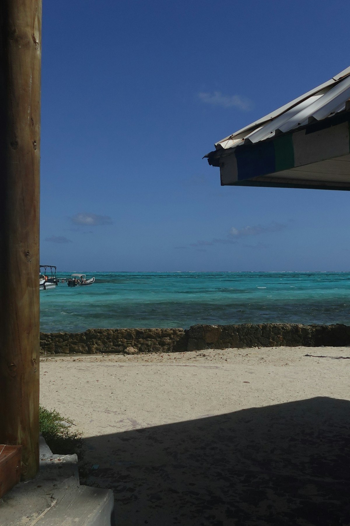 Turquoise Caribbean water viewed from the shore of San Andrés Island with a boat moored nearby