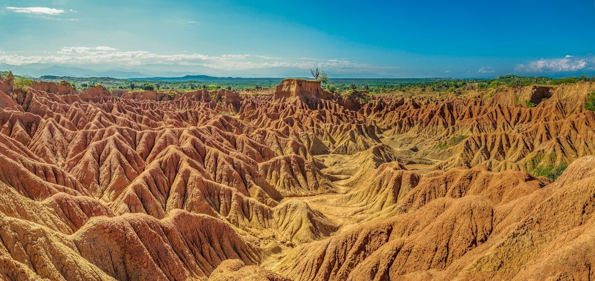Paisaje desertico del Desierto de la Tatacoa en Colombia, con formaciones de tierra roja bajo cielo azul