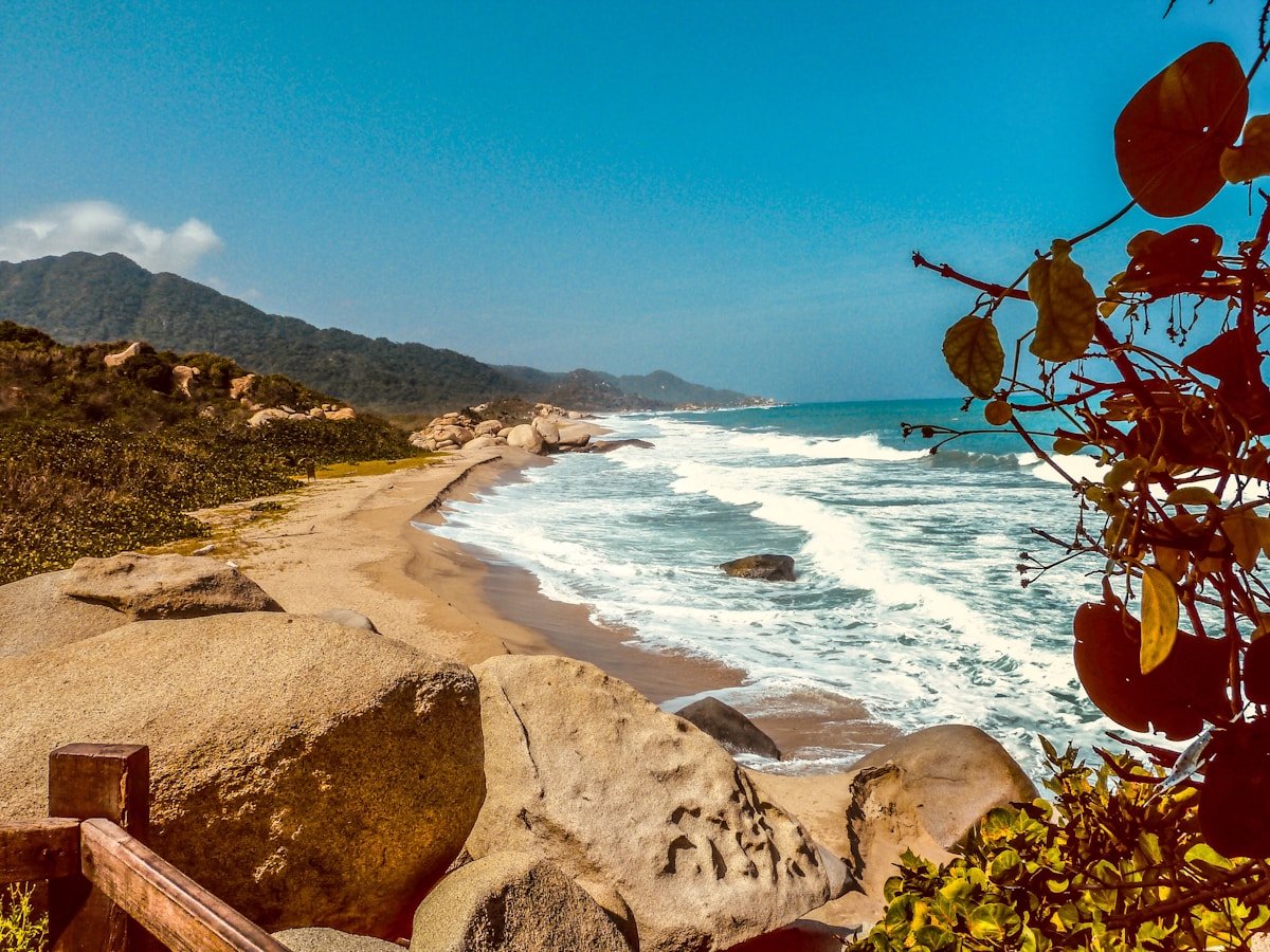 Rocky coastline with white sand beach and clear Caribbean water inside Tayrona National Park, Santa Marta, Colombia