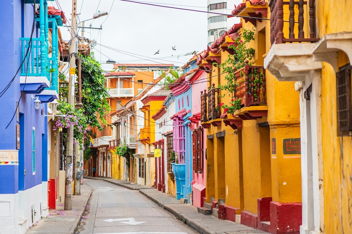 Narrow colourful street in Cartagena lined with flowering balconies and colonial buildings